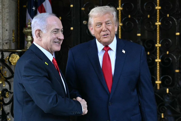 Israeli Prime Minister Benjamin Netanyahu and Donald Trump smile and shake hands