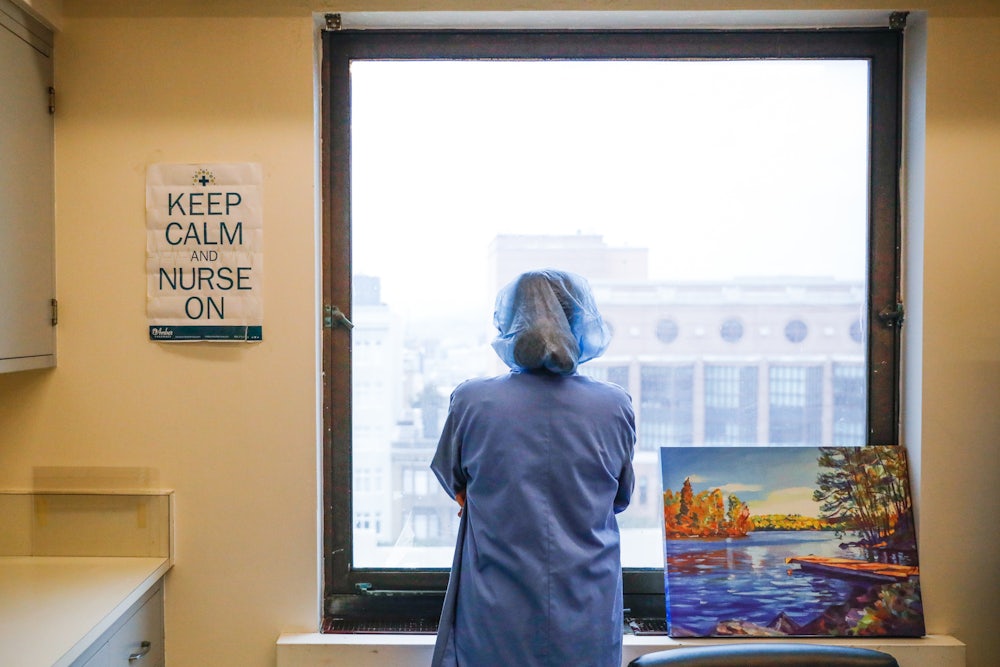 A nurse stares out the window
