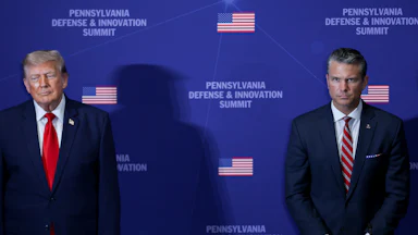 Donald Trump and Pete Hegseth stand in front of a backdrop that reads Pennsylvania Defense & Innovation Summit, a large gap between them.