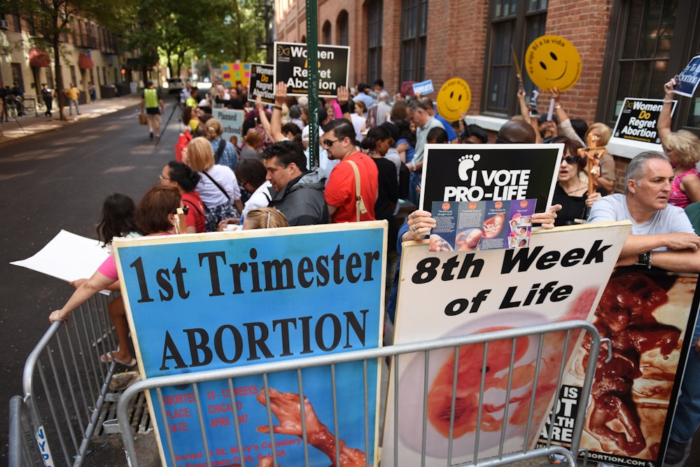 Anti-abortion protesters protest behind a barricade in front of Planned Parenthood on Mott Street in Manhattan.