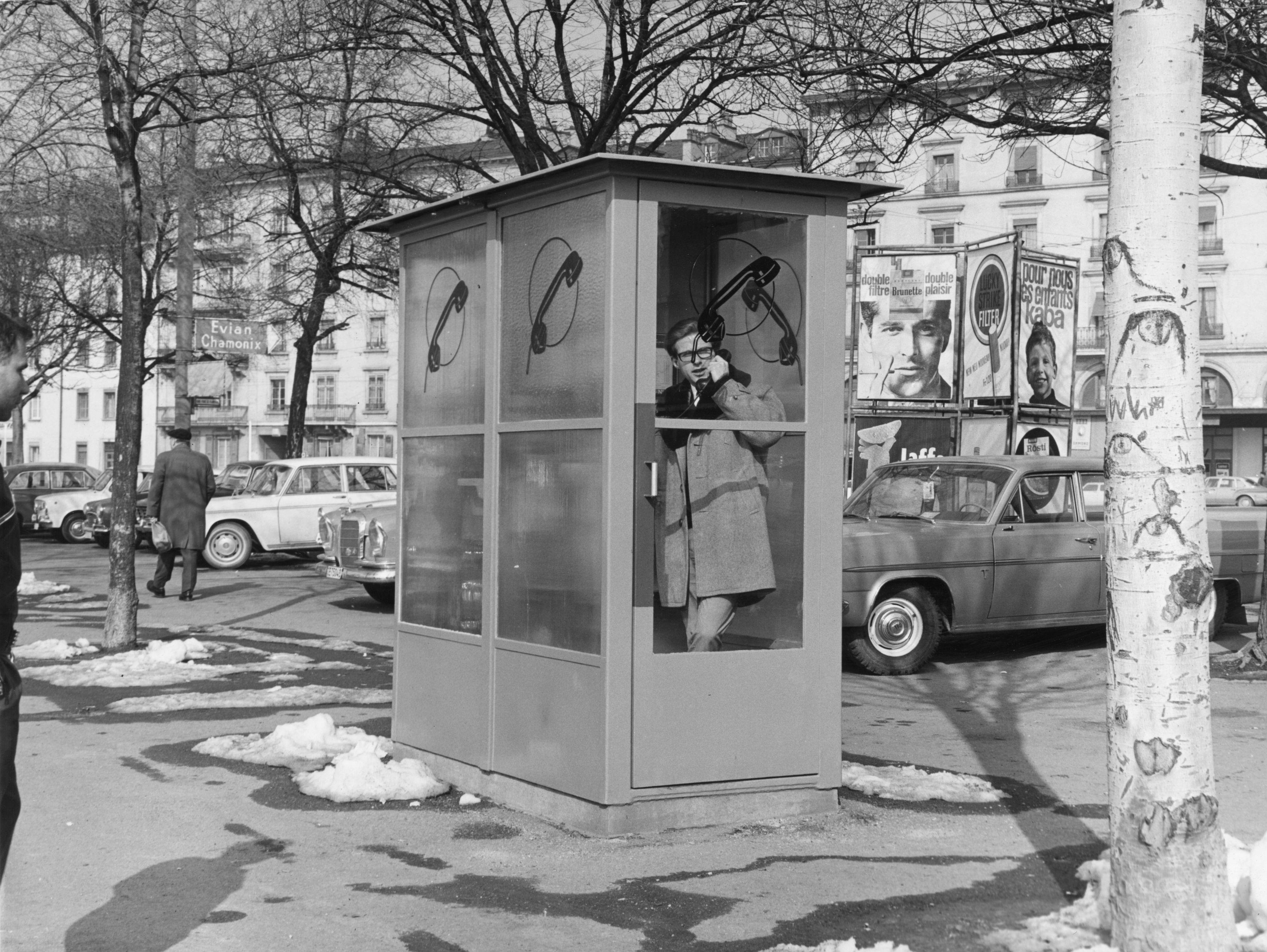 A man talking inside a telephone box 