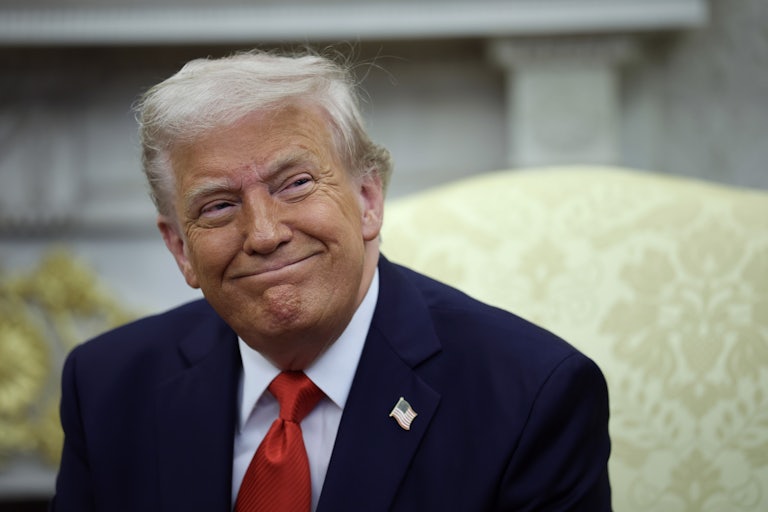 Donald Trump smiles while seated in the Oval Office of the White House.
