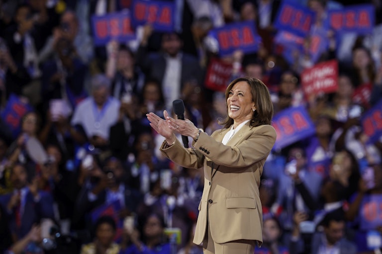 Kamala Harris smiles and claps onstage at the Democratic National Convention