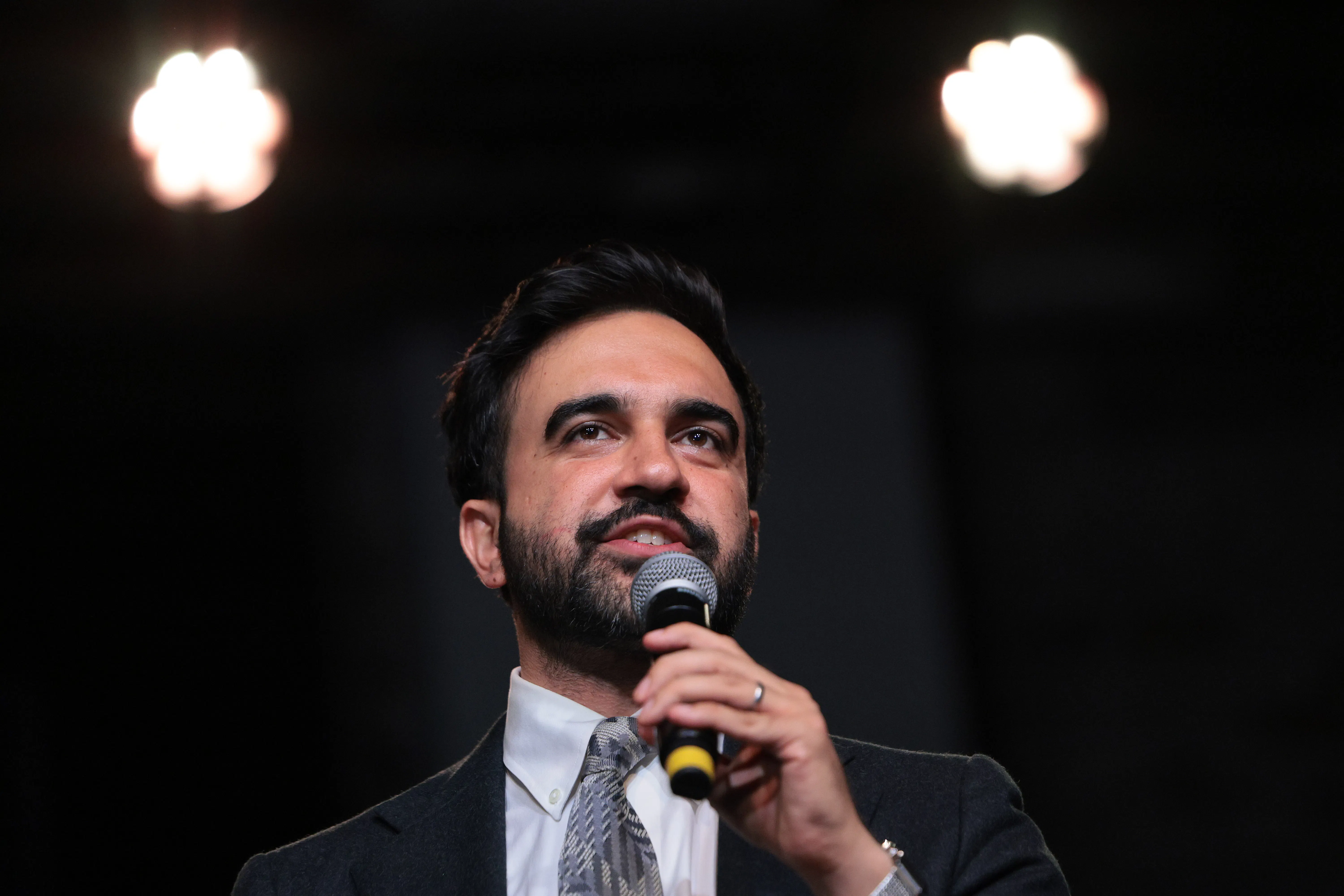 Zohran Mamdani speaking into a microphone