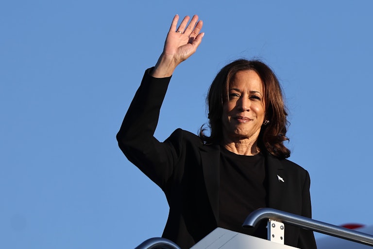 Kamala Harris waves as she boards a plane