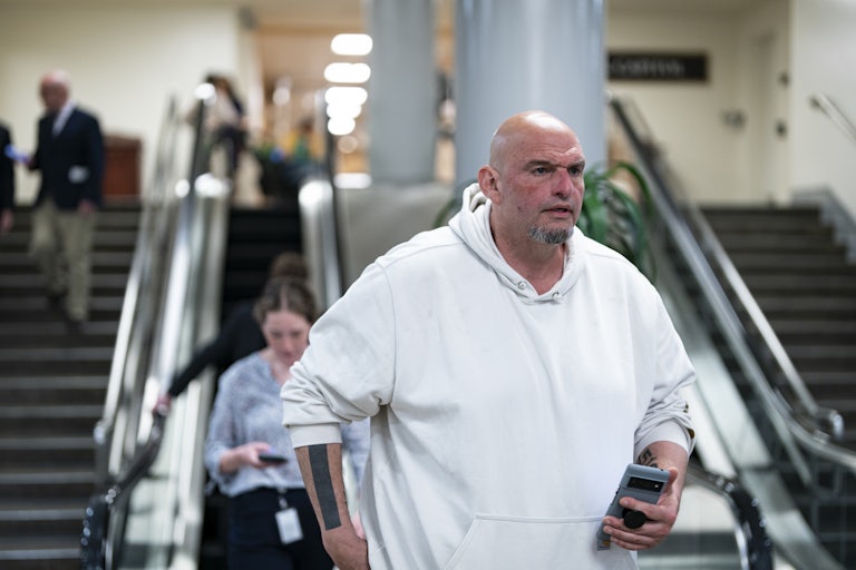 Senator John Fetterman wearing a white hoodie walks through the Capitol.