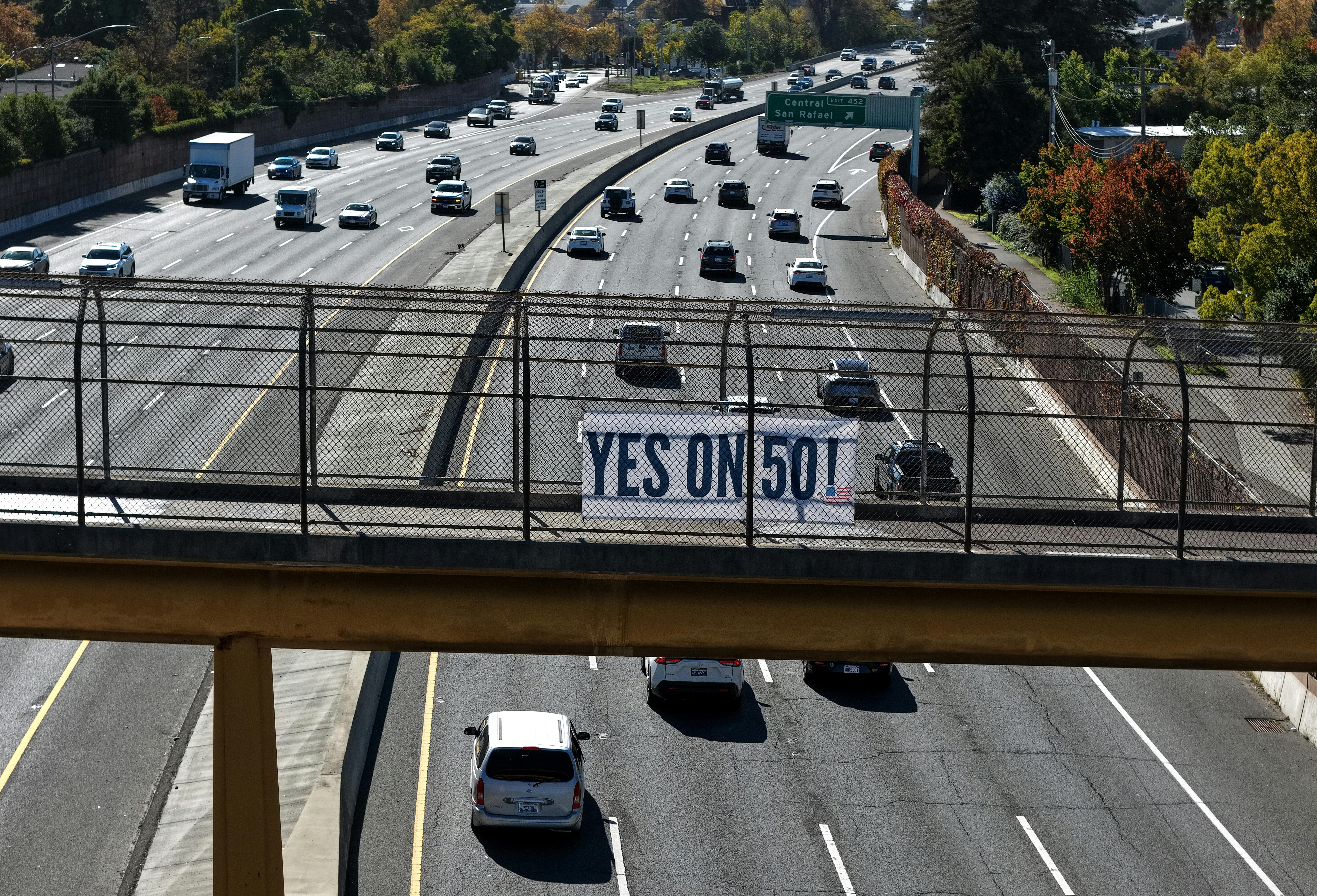 A Yes on 50 sign is posted on a walkway over the 101 in San Rafael, California.