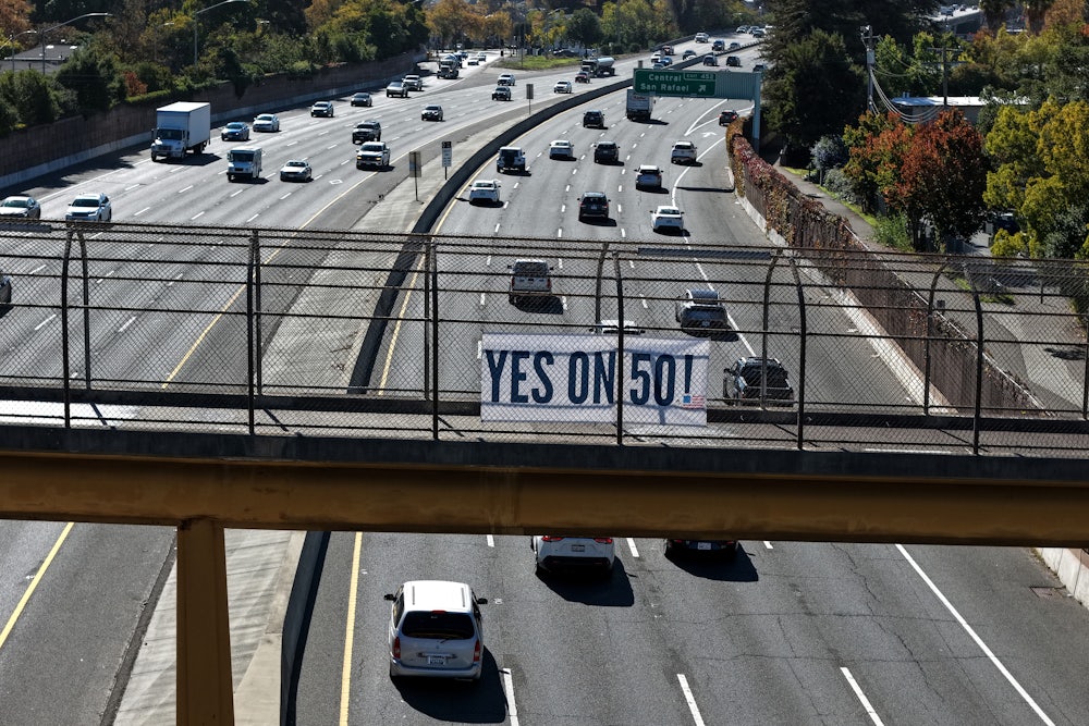 A Yes on 50 sign is posted on a walkway over the 101 in San Rafael, California.