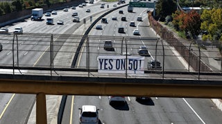 A Yes on 50 sign is posted on a walkway over the 101 in San Rafael, California.