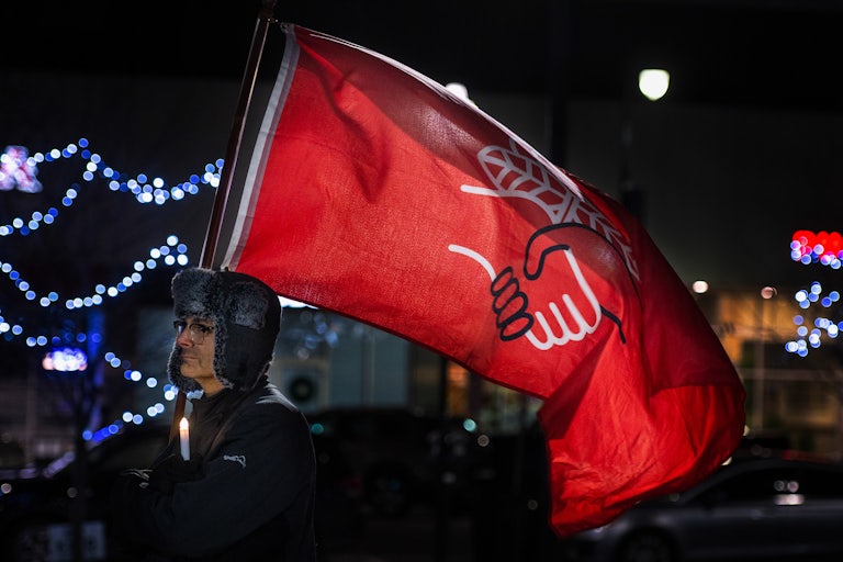 A man holds a Democratic Socialists of America flag