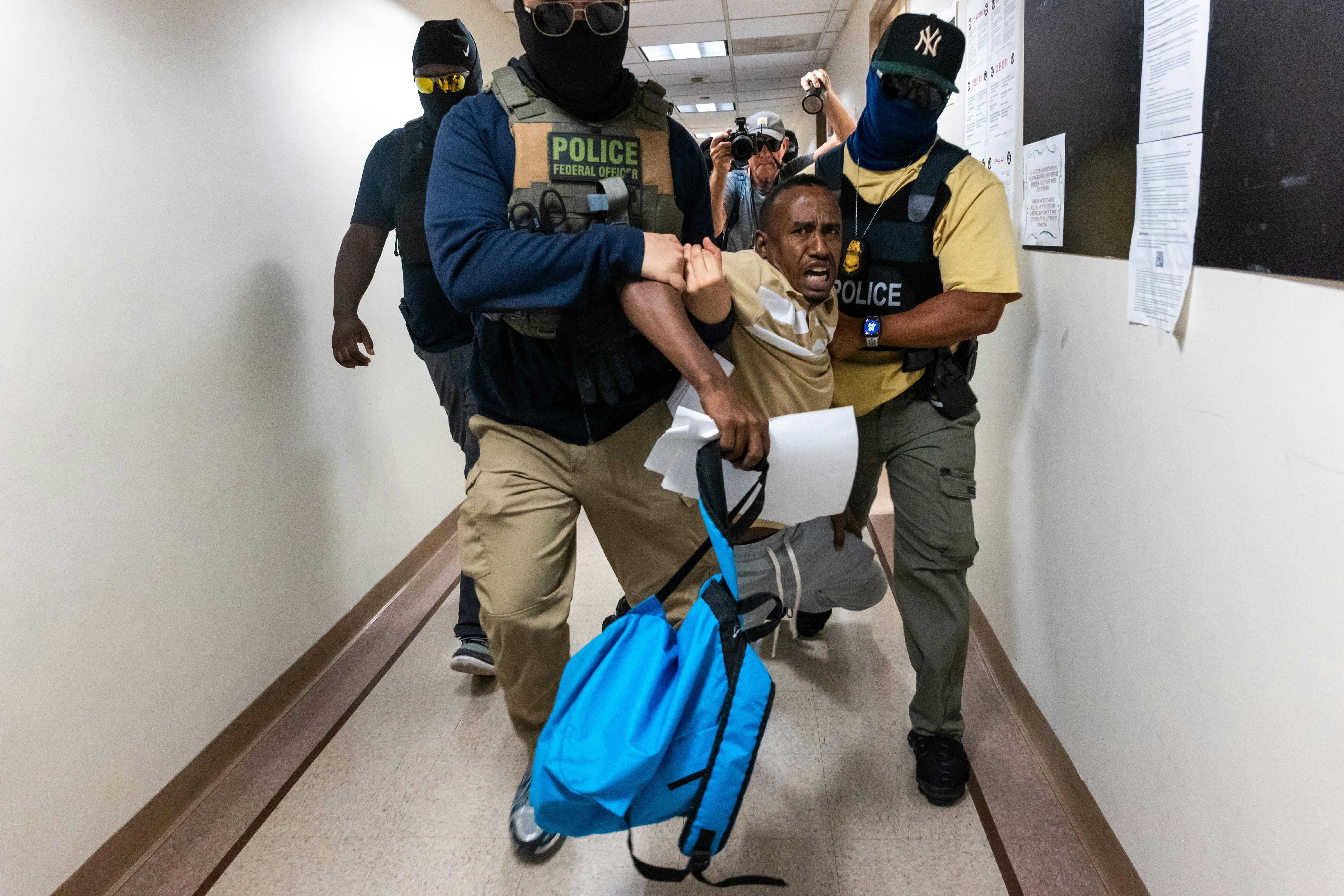Federal agents, including members of ICE, drag a man away after his court hearing as they patrol the halls of immigration court at the Jacob K. Javitz Federal Building on July 24, 2025 in New York City. 