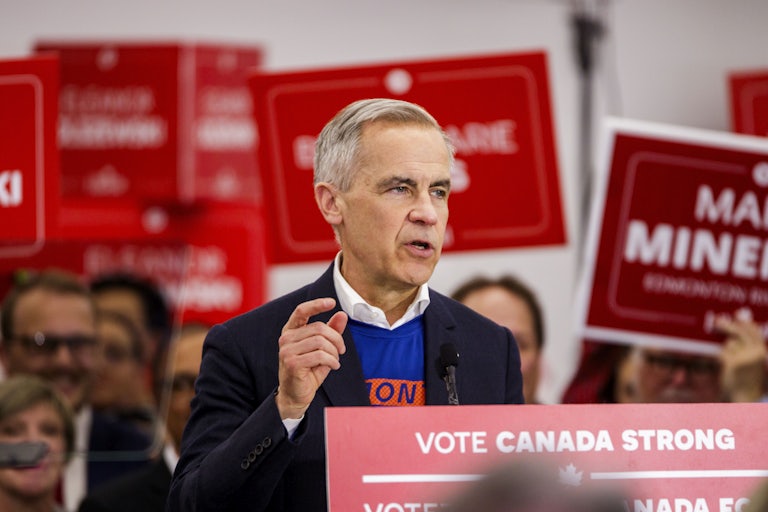 Canadian Prime Minister Mark Carney gestures while speaking at a podium during a campaign event