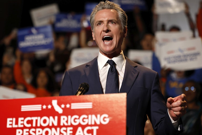 California Governor Gavin Newsom gestures and speaks while standing at a podium
