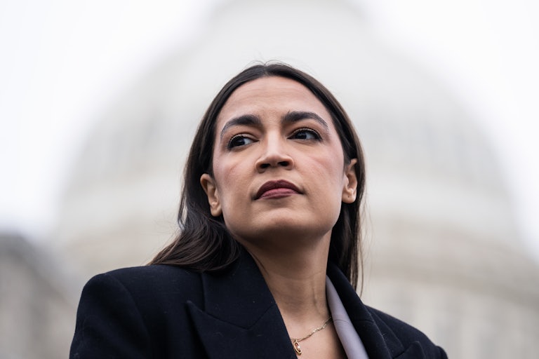 Representative Alexandria Ocasio-Cortez looks to the side while standing in front of the U.S. Capitol