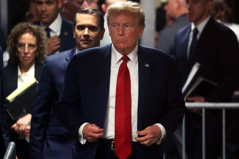 Donald Trump walking in the courthouse, others surround him