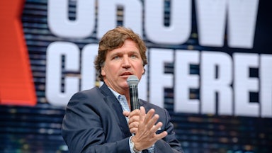 Tucker Carlson speaking on a mic.