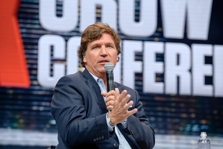 Tucker Carlson speaking on a mic.