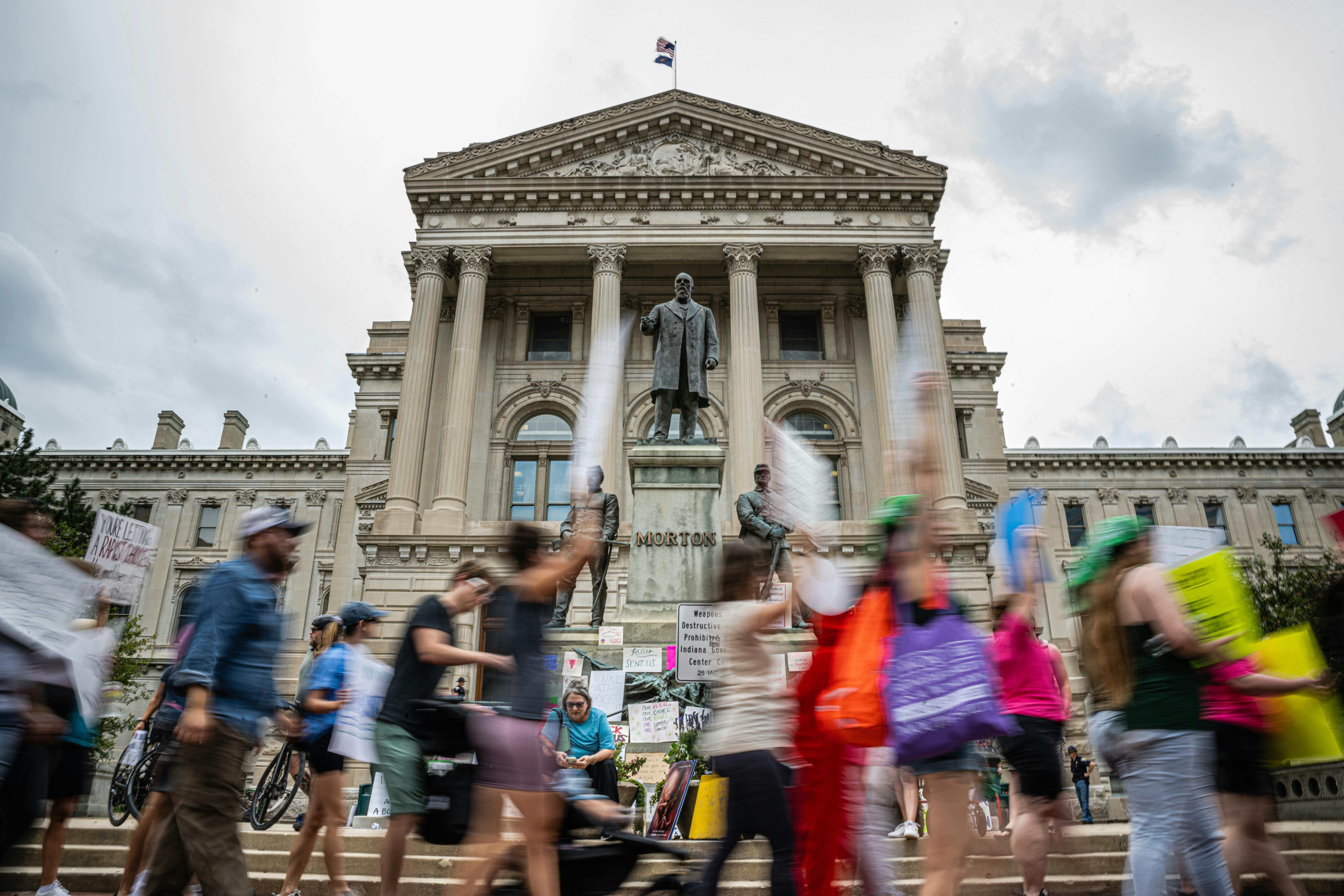 People protest in front of the Indiana state Capitol.