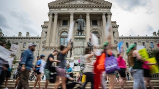 People protest in front of the Indiana state Capitol.