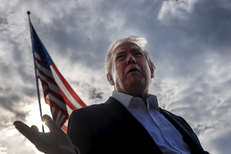 Trump stands in front of an American flag outside the White House
