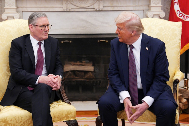Donald Trump looks at British Prime Minister Keir Starmer as they sit next to each other in the Oval Office