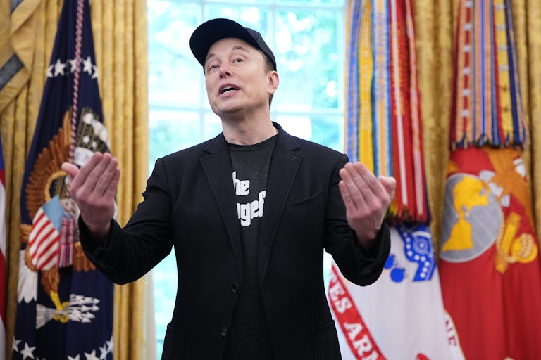 Elon Musk gestures while speaking in the Oval Office