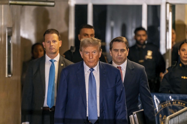 Donald Trump arrives at a Manhattan courthouse, flanked by attorneys.