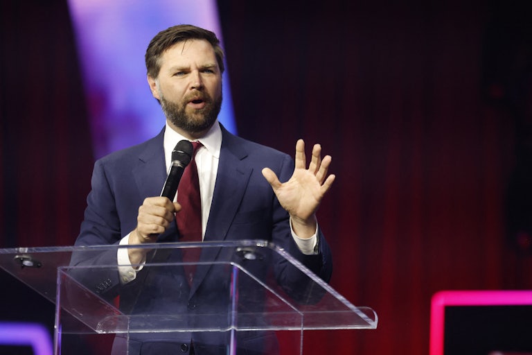 J.D. Vance holds a microphone while speaking at a podium
