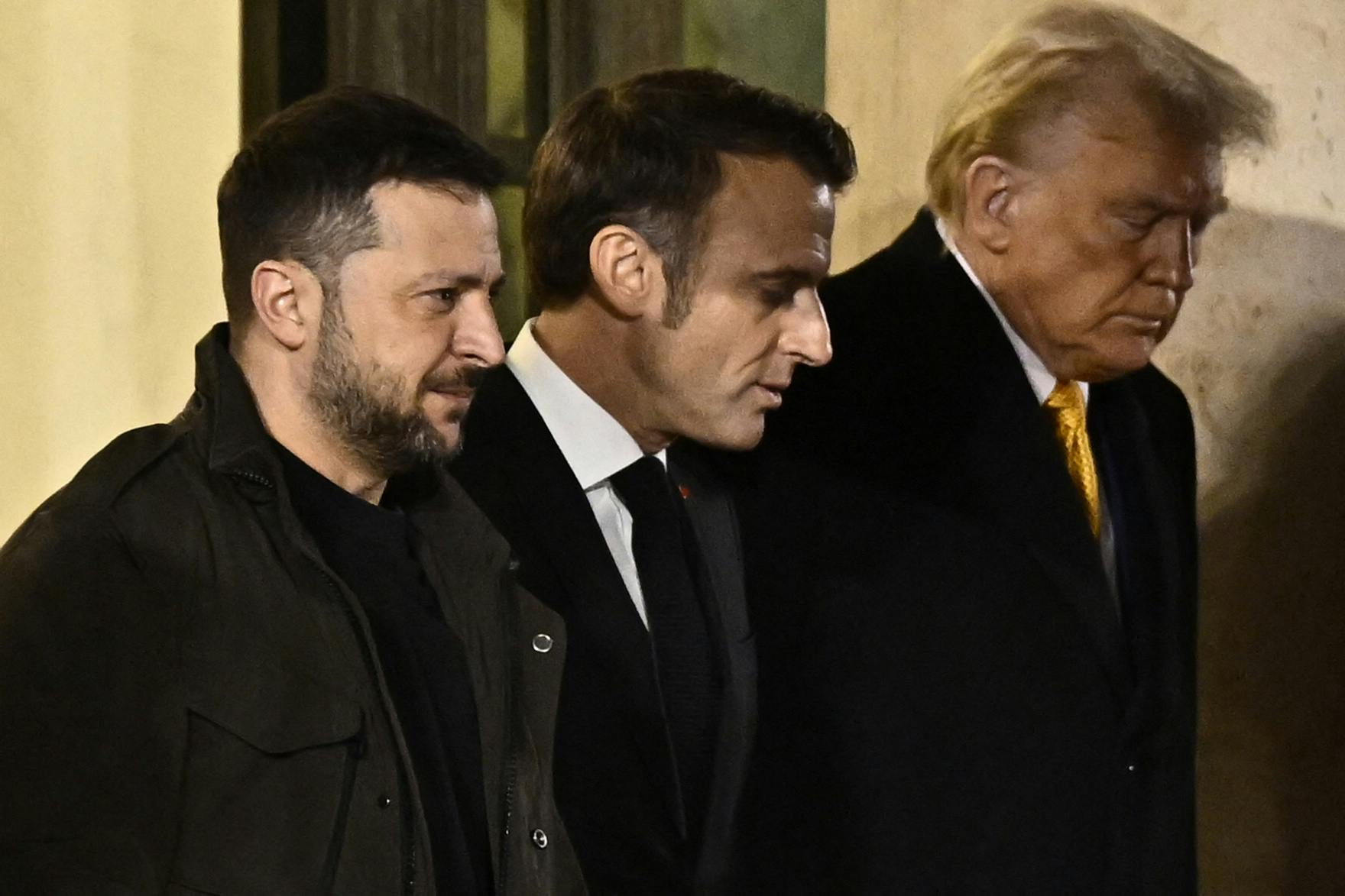 France's President Emmanuel Macron walks with president-elect Donald Trump and Ukraine's President Volodymyr Zelensky after a meeting at the Elysee Presidential Palace in Paris on December 7, 2024. 