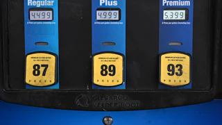 A gas station pump shows prices per gallon