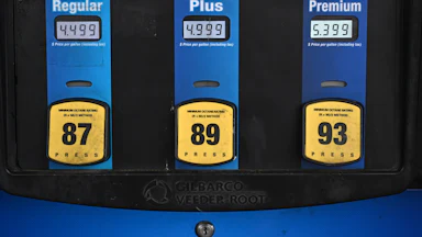 A gas station pump shows prices per gallon