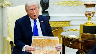 Donald Trump sits in the Oval Office and speaks while holding up a rendering of the gilded ballroom he's building at the White House