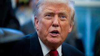 Donald Trump speaks while sitting at his desk in the Oval Office