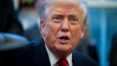 Donald Trump speaks while sitting at his desk in the Oval Office