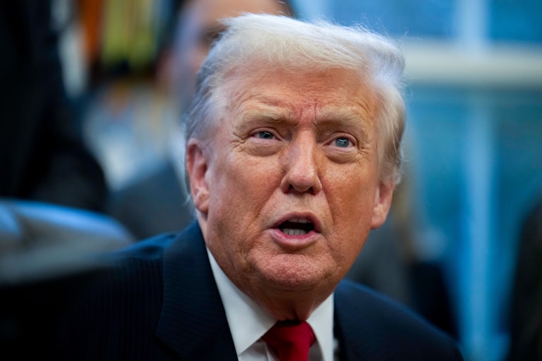 Donald Trump speaks while sitting at his desk in the Oval Office