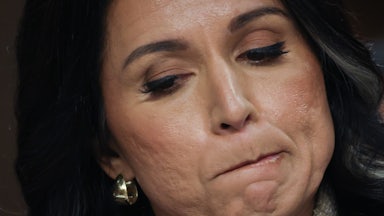 Director of National Intelligence Tulsi Gabbard presses her lips together and looks down during a Senate hearing