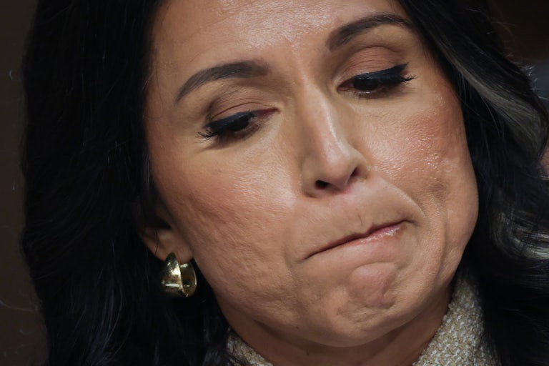 Director of National Intelligence Tulsi Gabbard presses her lips together and looks down during a Senate hearing