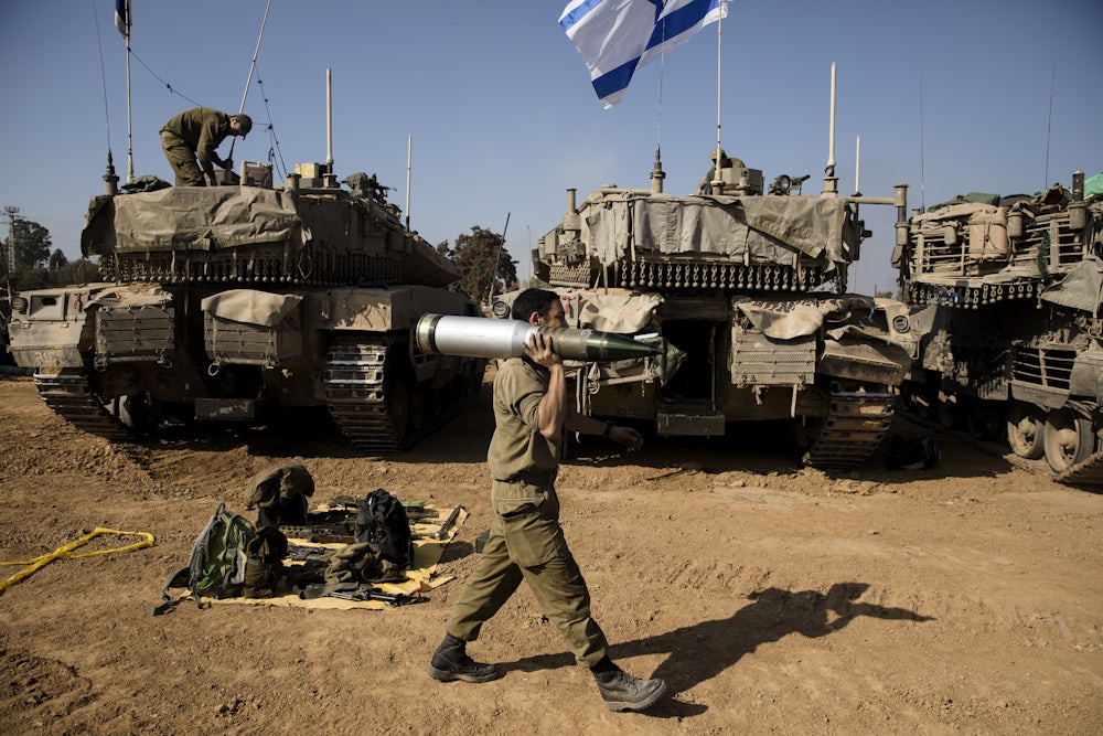 An Israeli soldier carries a tank shell after returning from the Gaza Strip