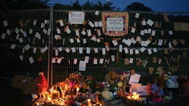"Maine Grieves" and "You Shall Not Oppress a Stranger" signs near a vigil for the man shot by ICE agents in Maine