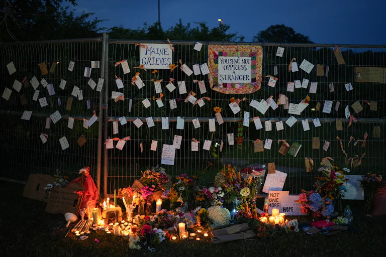 "Maine Grieves" and "You Shall Not Oppress a Stranger" signs near a vigil for the man shot by ICE agents in Maine
