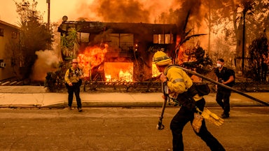 Firefighters work the scene as an apartment building burns during the Eaton fire in the Altadena area of Los Angeles County, California.