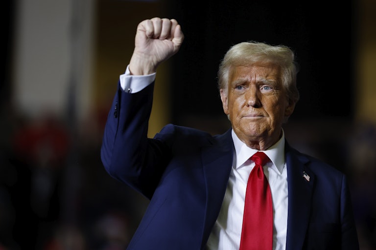 Donald Trump holds up a fist during a campaign rally