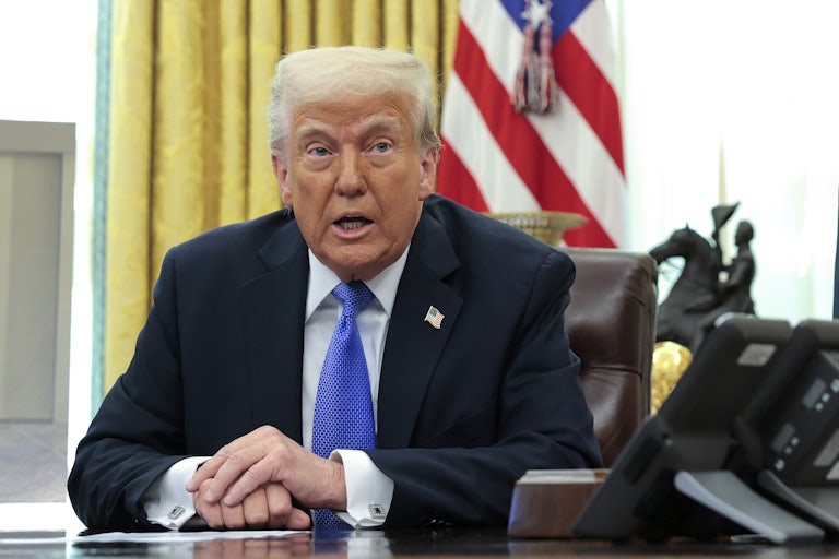 Donald Trump speaks while seated behind his desk in the White House.
