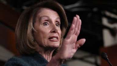 A close up of House Majority Leader Nancy Pelosi, gesturing with her hand.