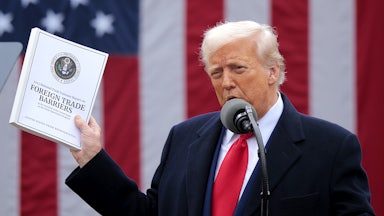 Donald Trump holds up a copy of a 2025 National Trade Estimate Report as he speaks during a “Make America Wealthy Again” trade announcement event in the Rose Garden at the White House.