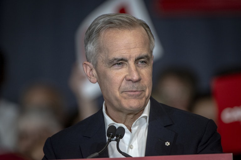 Canadian Prime Minister Mark Carney stands at a podium during a rally
