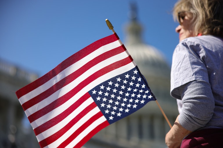 A demonstrator holds an upside-down U.S. flag during a sit-in protest against Republicans’ budget outside the U.S. Capitol in Washington, D.C.