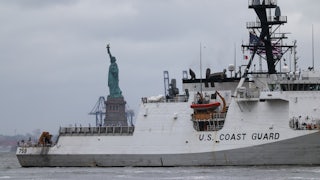 U.S. Coast Guard ship sails near the Statue of Liberty.