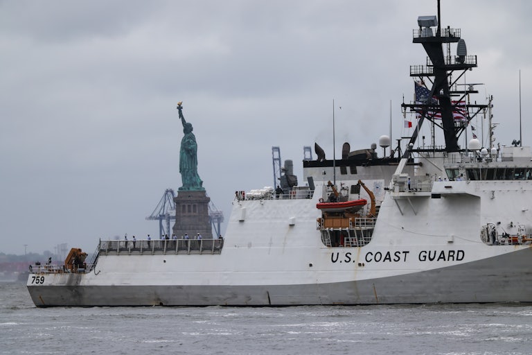 U.S. Coast Guard ship sails near the Statue of Liberty.