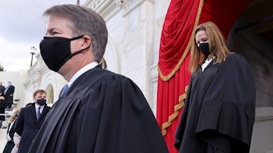 A masked Brett Kavanaugh is trailed by a masked Amy Coney Barrett as the two Justices make their way to their seats.